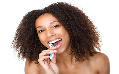 A young teen girl brushing her teeth