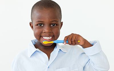 smiling boy brushing teeth