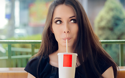 A woman drinking soda out of a cup