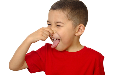A young boy plugging his nose