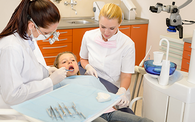 A female dentist working on a young child