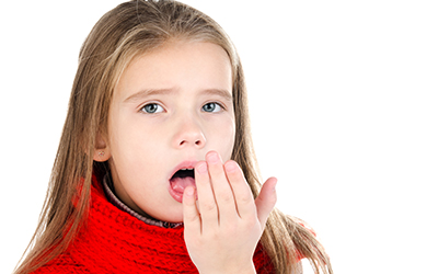 A young girl blowing into her hand to check her breath