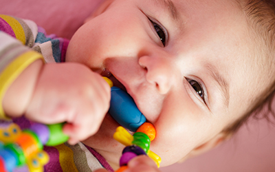 Baby gnawing on a toy