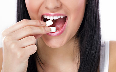 Woman putting gum into her mouth