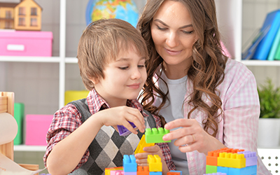 Woman and young boy playing with lego