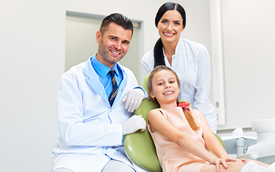 Dental team with a happy smiling patient at the dentist office