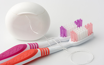 Two toothbrushes and dental floss