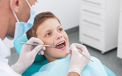 A young boy sitting in a dental chair for a checkup